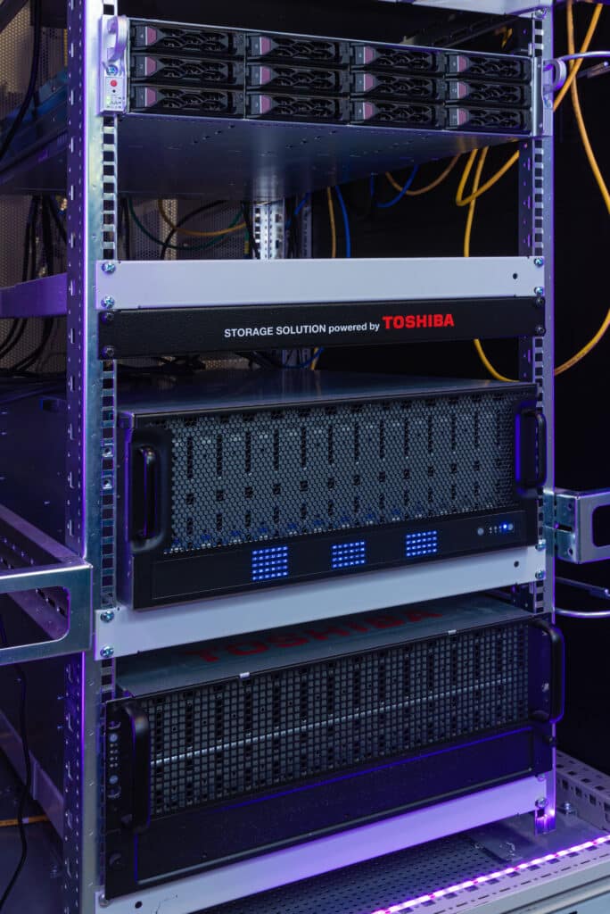 Серверная стойка для хранения данных с питанием от Toshiba с синими светодиодными индикаторами состояния.